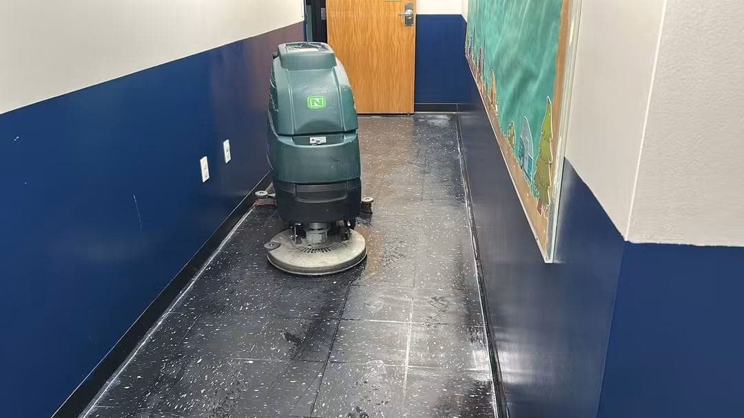 A NovaSpark technician operating an automatic floor scrubber during a strip-and-wax job