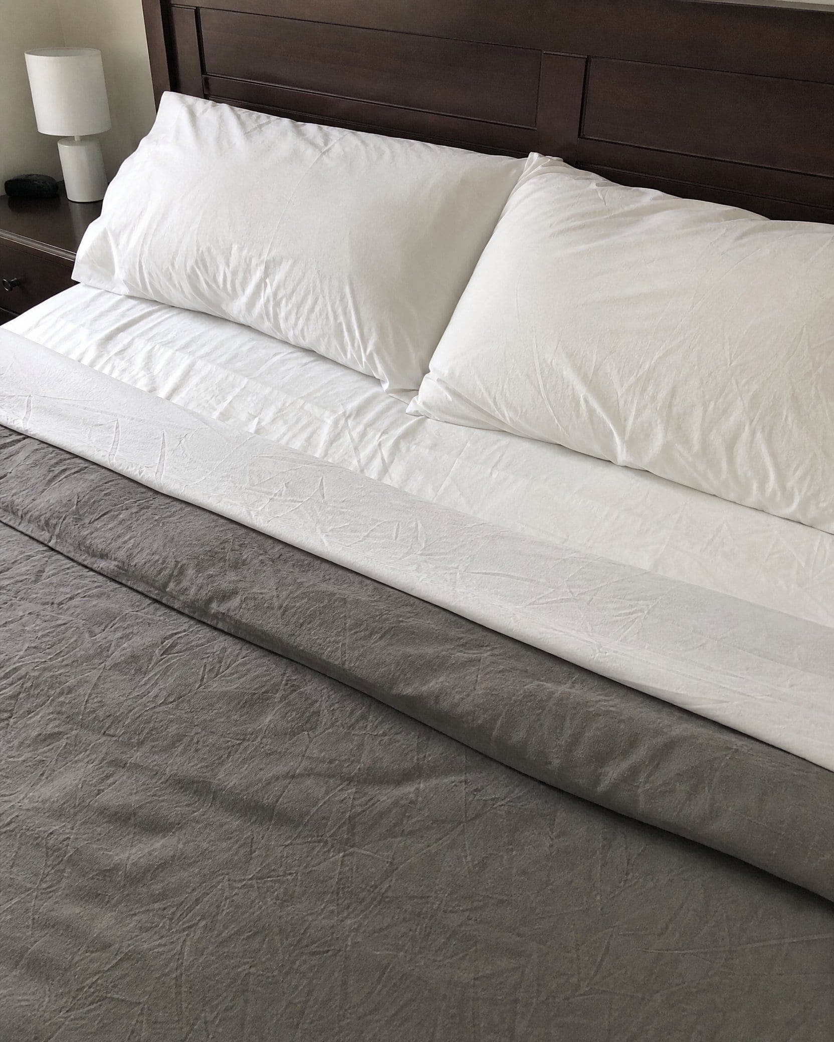 A freshly made bed with crisp white pillows after a NovaSpark mattress cleaning